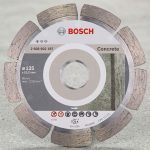 Hình ảnh Đĩa cắt bê tông 125mm Bosch 2608602197 chính hãng với thiết kế lưỡi cắt kim cương phân đoạn chuyên dụng cho bê tông, gạch, đá xây dựng và các vật liệu cứng. Sản phẩm có đường kính 125mm, lỗ trục 22.23mm, khả năng cắt nhanh, ít rung lắc, tuổi thọ cao và phù hợp với nhiều dòng máy cắt cầm tay. Đĩa cắt Bosch 2608602197 là lựa chọn lý tưởng cho thợ xây dựng, thi công công trình và các ứng dụng cắt bê tông chuyên nghiệp, đảm bảo hiệu suất làm việc ổn định và đường cắt chính xác.